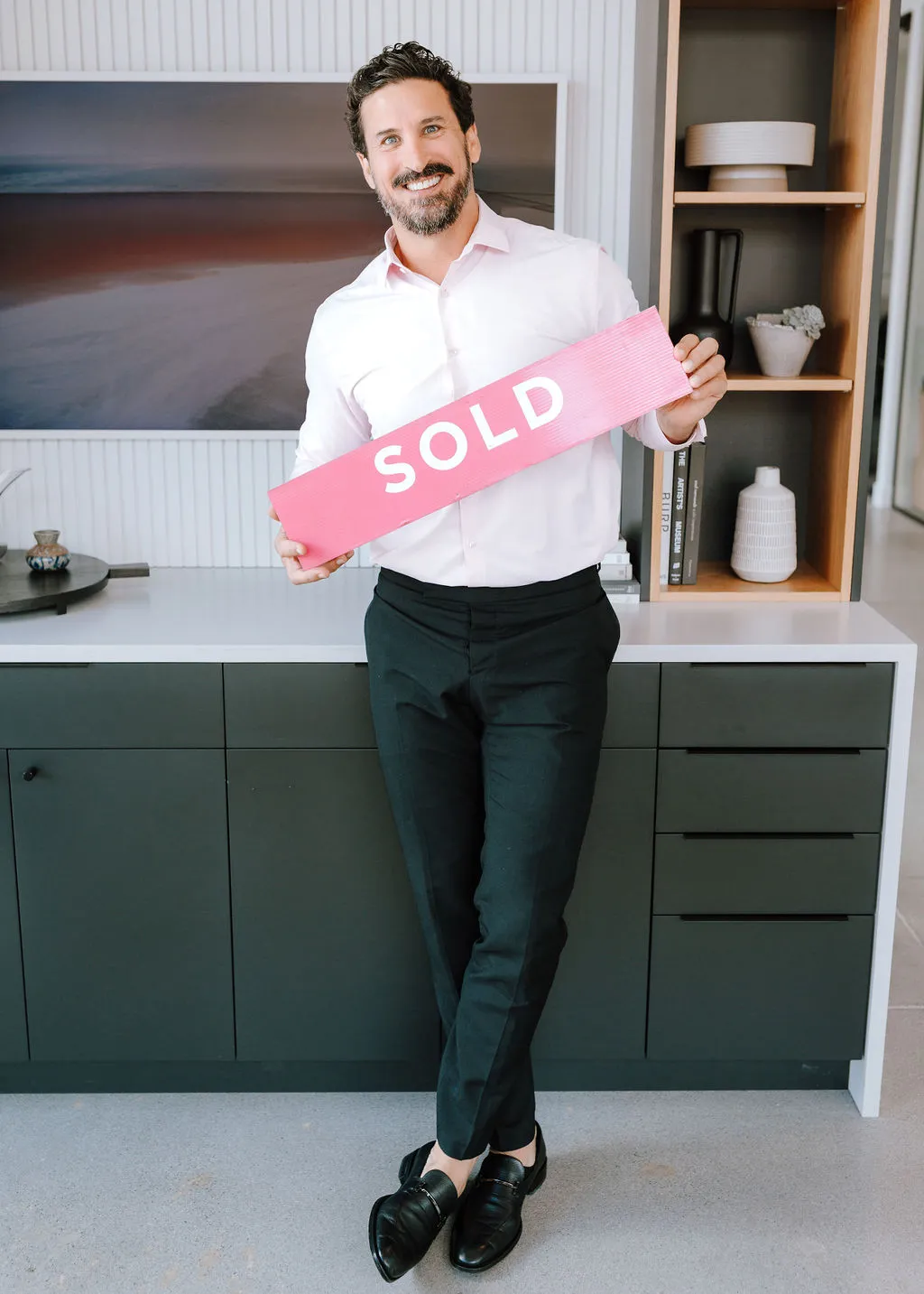 Jay Blackford holding a sold sign